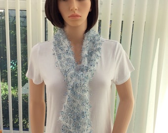May include: A white t-shirt with a light blue and white scarf. The scarf is made of a soft, fluffy yarn.