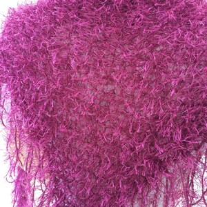 May include: A magenta fuzzy knit shawl with a fringe border.