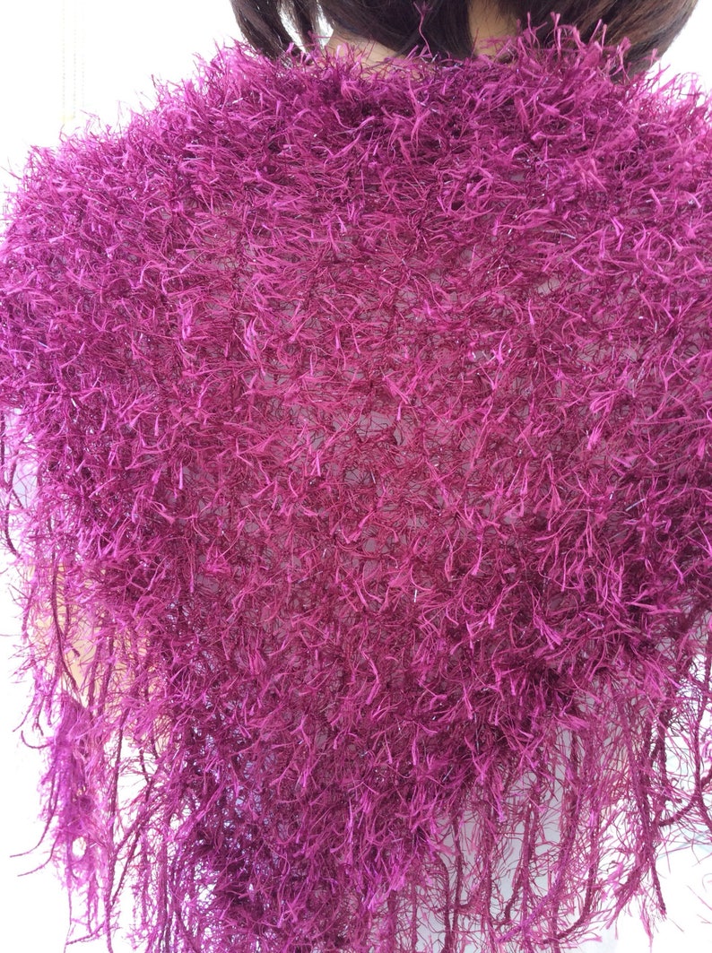 May include: A magenta fuzzy knit shawl with a fringe border.