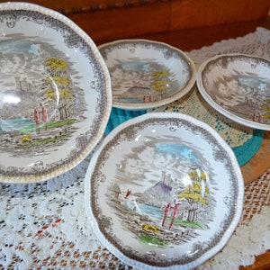May include: Set of four vintage ceramic bowls with a brown and white floral pattern. The bowls feature a scenic landscape with a castle and trees.