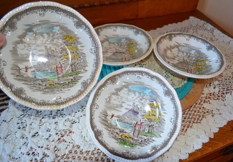 May include: Set of four vintage ceramic bowls with a brown and white floral pattern. The bowls feature a scenic landscape with a castle and trees.