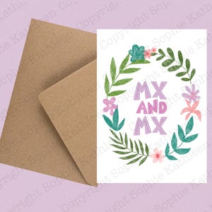 May include: A white greeting card featuring a floral wreath design with the text "MX AND MX" in purple and pink. It is presented with a brown envelope, ideal for sending a personalized message.