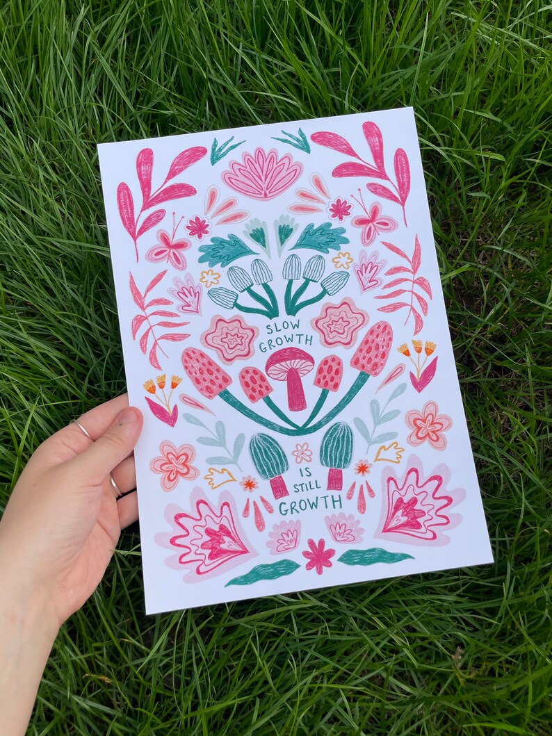 Pu&ograve; includere: Una stampa bianca con un design floreale rosa e verde. La stampa presenta il testo "Slow Growth is Still Growth".