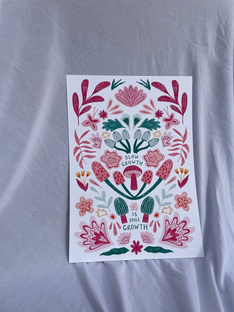 Pu&ograve; includere: Una stampa bianca con un design floreale in tonalit&agrave; rosa, verde e rosso. La stampa presenta funghi con il testo "Slow Growth is Still Growth".