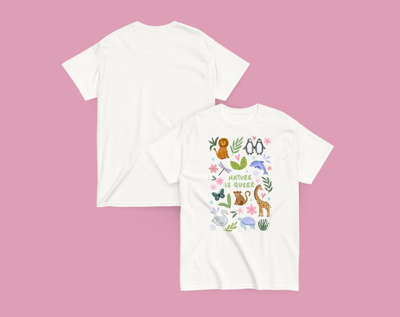 May include: Two white t-shirts on a pink background. One shirt displays a colorful graphic with the text "Nature is Queer" and illustrations of animals including a lion, penguins, and a giraffe. The other shirt is plain.