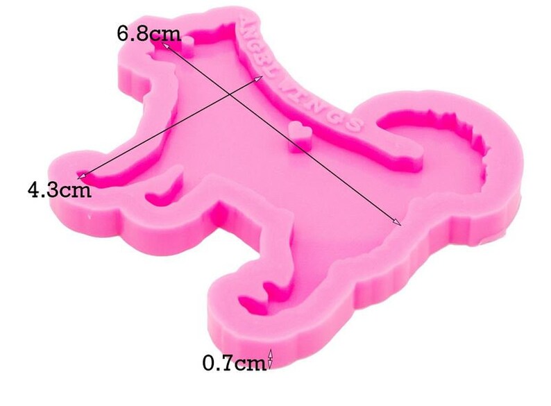 May include: A bright pink silicone mold shaped like a dog with a curled tail. The mold features the embossed text ANGEL WINGS and a small heart shape. Measurements indicated on the mold are 6.8 cm in length, 4.3 cm in width, and 0.7 cm in depth.