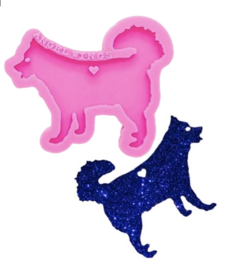 May include: A pink silicone mold shaped like a dog with the text ANGEL WINGS and a small heart embossed on the surface, accompanied by a dark blue glittery dog-shaped cutout that matches the mold's silhouette and features a small heart cutout.