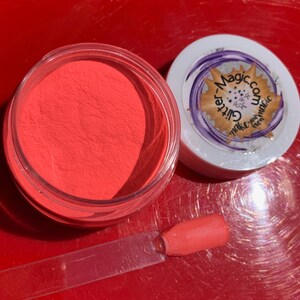 May include: A small jar of bright orange glitter powder with a clear lid. The jar is labeled "Glitter-Magic.com Make your magic even magic".