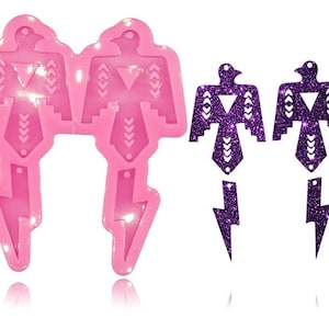 May include: Two pink silicone molds for making earrings in the shape of a Native American inspired bird with a lightning bolt design. The molds are shown next to two purple glitter earrings made from the molds.