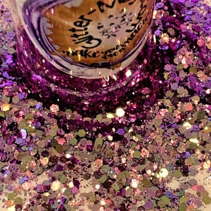 May include: A close-up of iridescent purple and gold glitter. The glitter is in a jar with a label that reads "Glitter - Make your dreams sparkle".