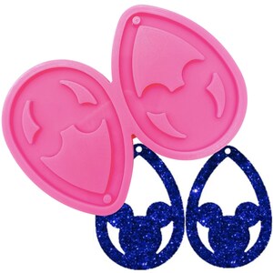 May include: A pink silicone mold for making teardrop-shaped earrings with a Mickey Mouse head design. Two finished blue glitter earrings are also shown. The earrings have a small hole at the top for attaching to earring hooks.