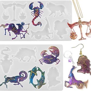 May include: Image features molds and finished resin jewelry pieces with a celestial theme. The molds include zodiac symbols. Finished pieces include a Libra pendant necklace and earrings with a profile and a Capricorn design. Colors include purple, blue, and gold.