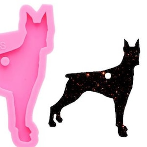 May include: Pink silicone mold of a Doberman Pinscher dog silhouette. The mold is used to create resin crafts.
