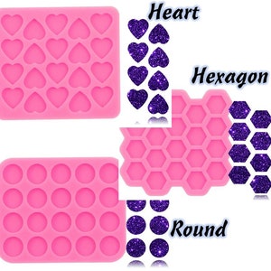 May include: Pink silicone mold with three different shapes: heart, hexagon, and round. Each shape is shown with a purple glitter version of the shape.
