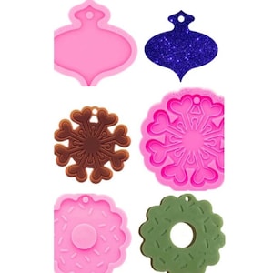 May include: Six silicone molds for making ornaments and other crafts. The molds are pink and feature a snowflake, a donut, and a Christmas tree ornament.