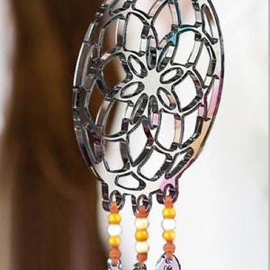 May include: A silver dreamcatcher necklace with a beaded fringe and three feather charms. The dreamcatcher is a circular design with a web-like pattern.