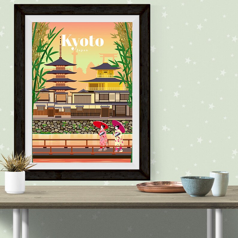 May include: A vintage travel poster with an illustration of a traditional Japanese temple in Kyoto, Japan. The poster features two women in kimonos walking on a bridge with red umbrellas.
