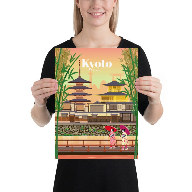 May include: A colorful illustration of a traditional Japanese temple with a pagoda, surrounded by bamboo trees. Two women in kimonos walk along a path with red umbrellas. The text "Kyoto, Japan" is displayed at the top of the image.