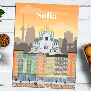 May include: A colorful illustration of the city of Sofia, Bulgaria. The illustration features a large white church with green domes, surrounded by colorful buildings. The text "Sofia, Bulgaria" is at the top of the illustration.