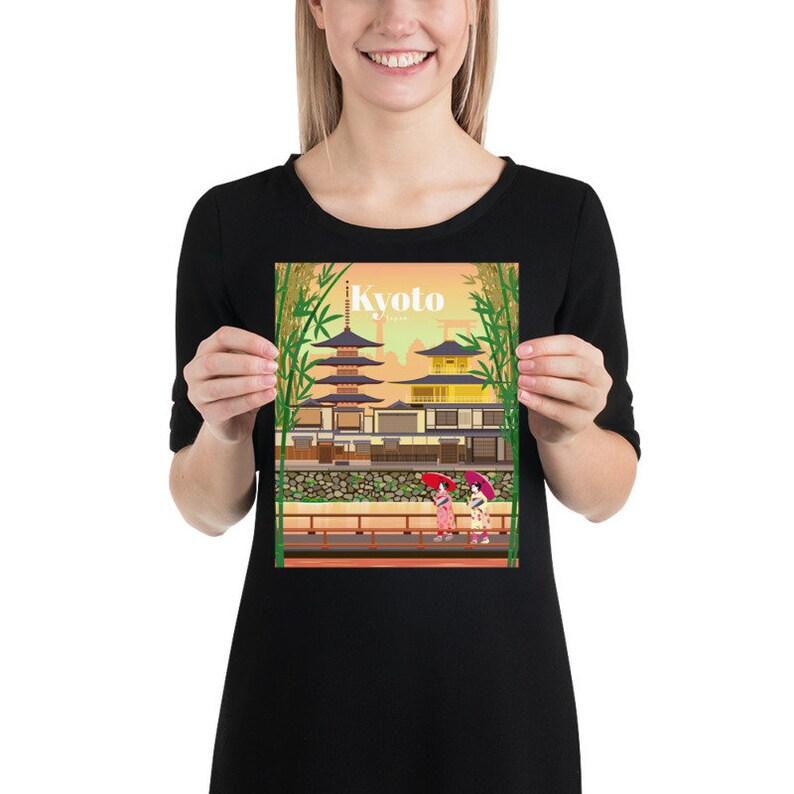 May include: A colorful illustration of a traditional Japanese temple with a pagoda, surrounded by bamboo trees. Two women in kimonos walk along a path with red umbrellas. The text "Kyoto, Japan" is displayed at the top of the image.