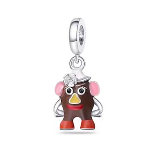 May include: A silver charm featuring a cartoon character with a brown head, pink ears, and red shoes. The charm has a yellow nose, red lips, and a white hat with a flower. The charm is designed to hang from a bracelet or necklace.