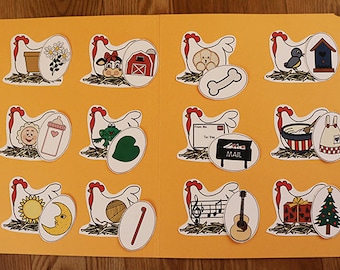May include: A set of 12 colourful, illustrated cards featuring a white hen with a red comb and a variety of objects inside the egg. The text "Lay an Egg!" is on the bottom right corner of the card.