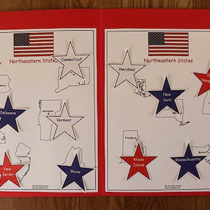May include: A red folder with a white label that says "State Capitals" and a map of the Northeastern United States with stars representing each state. The states are labeled with their names and the stars are labeled with the state capitals.