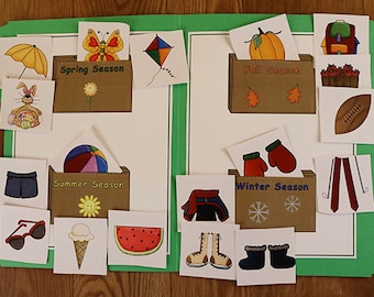May include: A green file folder displaying seasonal images. The folder is divided into four sections labelled Spring, Summer, Autumn, and Winter. Each section contains illustrations of items associated with the season, including a butterfly, shorts, a pumpkin, and mittens.