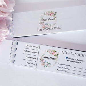 Puede incluir: Un libro de vales de regalo blanco con un dise&ntilde;o floral y el texto "Inner Peace Gift Voucher Book". El libro tiene una encuadernaci&oacute;n en espiral e incluye un vale separado con el texto "Inner Peace Gift Voucher" y espacio para rellenar el importe del vale, la fecha de caducidad y la autorizaci&oacute;n.