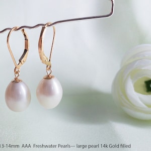 Peut inclure: Une paire de boucles d'oreilles en perles d'eau douce blanches avec des fermoirs à levier en or 14 carats. Les perles mesurent environ 10,5-11,5 mm x 13-14 mm.