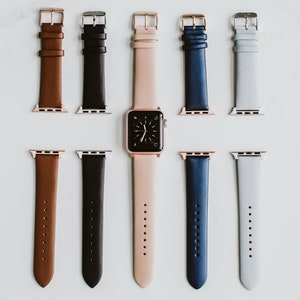 Puede incluir: Un conjunto de siete correas de reloj de cuero en varios colores, incluyendo marr&oacute;n, negro, rosa, azul y gris. Las correas est&aacute;n dispuestas en dos filas, con una esfera de reloj en el centro.