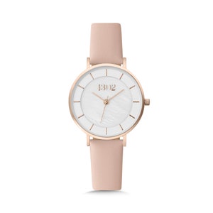 May include: A rose gold watch with a white face and a pink leather band. The watch face has a white mother-of-pearl texture and the brand name "1302" is printed on the face.