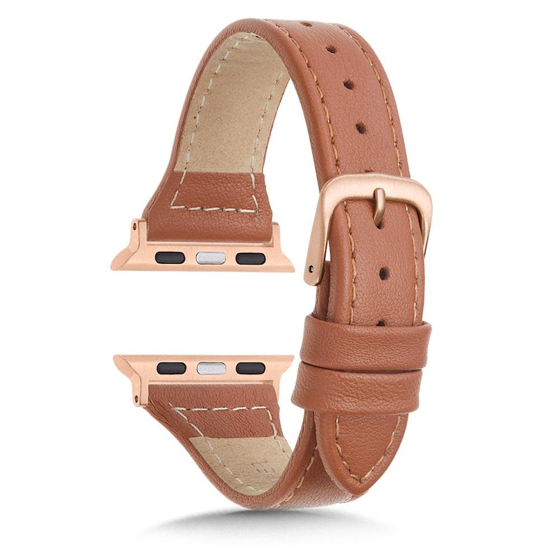 May include: A brown leather watch strap with a rose gold buckle and connectors. The strap is made of smooth leather and has a light beige underside. The rose gold connectors have two small holes for attachment.