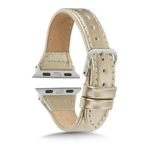 May include: A gold-coloured leather watch strap with a silver buckle and connectors. The strap is made of a smooth, shiny material and has a classic design. The watch strap is designed to fit a smartwatch.