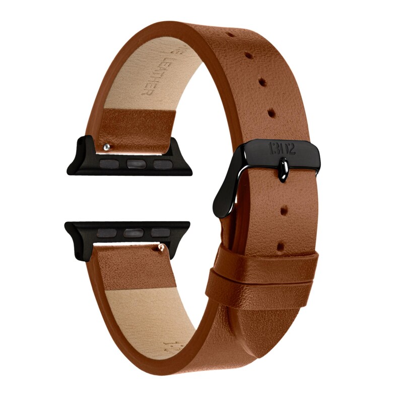 Pode incluir: Uma pulseira de rel&oacute;gio em couro castanho-claro com textura lisa e fivela de metal preto. A pulseira inclui dois conectores de metal preto nas extremidades para fixa&ccedil;&atilde;o. O interior &eacute; forrado com material bege claro e apresenta texto.
