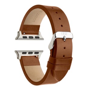May include: A brown leather watch band featuring a silver-toned metal buckle engraved with the text 1302. The band includes silver-toned metal connectors designed for attachment to a smartwatch, with a smooth light beige interior lining.