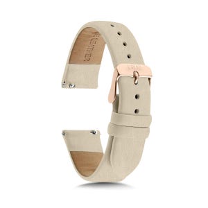 May include: A beige watch strap made of leather with a rose gold-toned metal buckle. The strap features a series of adjustment holes and a metal pin buckle engraved with the text 1302. The interior of the strap is stamped with the text GENUINE LEATHER.