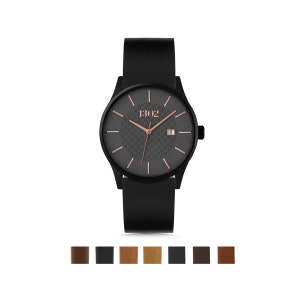 Pode incluir: Um rel&oacute;gio de pulso de couro preto com um mostrador preto e detalhes em ouro rosa. O mostrador do rel&oacute;gio tem um padr&atilde;o de fibra de carbono e exibe a data e o nome da marca "1302".