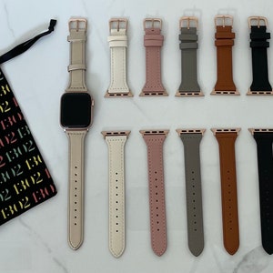 May include: An Apple Watch with a light beige leather strap and rose gold hardware, with a selection of interchangeable straps in various colours. A black drawstring bag with the text "1302" in multiple colours is also present.