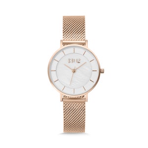 May include: A rose gold watch with a white face and a mesh band. The watch face has a white mother-of-pearl dial with a rose gold 1302 logo.