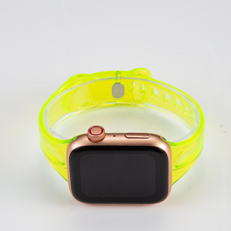 K&ouml;nnte beinhalten: Ein neon-gelbes, transparentes Silikon-Armband f&uuml;r eine Apple Watch. Das Armband ist durchsichtig und hat eine glatte Oberfl&auml;che. Das Zifferblatt der Uhr ist schwarz und das Geh&auml;use der Uhr ist ros&eacute;gold.