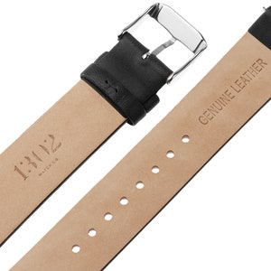 Pode incluir: Uma pulseira de rel&oacute;gio em couro preto com uma fivela de metal prateado. O lado interno da pulseira &eacute; bege e apresenta o texto 1:112 WATCH CO. e GENUINE LEATHER, juntamente com uma s&eacute;rie de orif&iacute;cios de ajuste para a fivela.