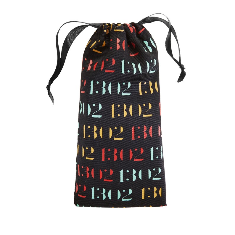 Pode incluir: Uma bolsa de tecido preto com cord&atilde;o, apresentando um padr&atilde;o repetitivo do texto 1302 impresso em cores alternadas vermelho, amarelo e azul claro. A bolsa possui um fecho de fita preta no topo que se ajusta para prender o conte&uacute;do.