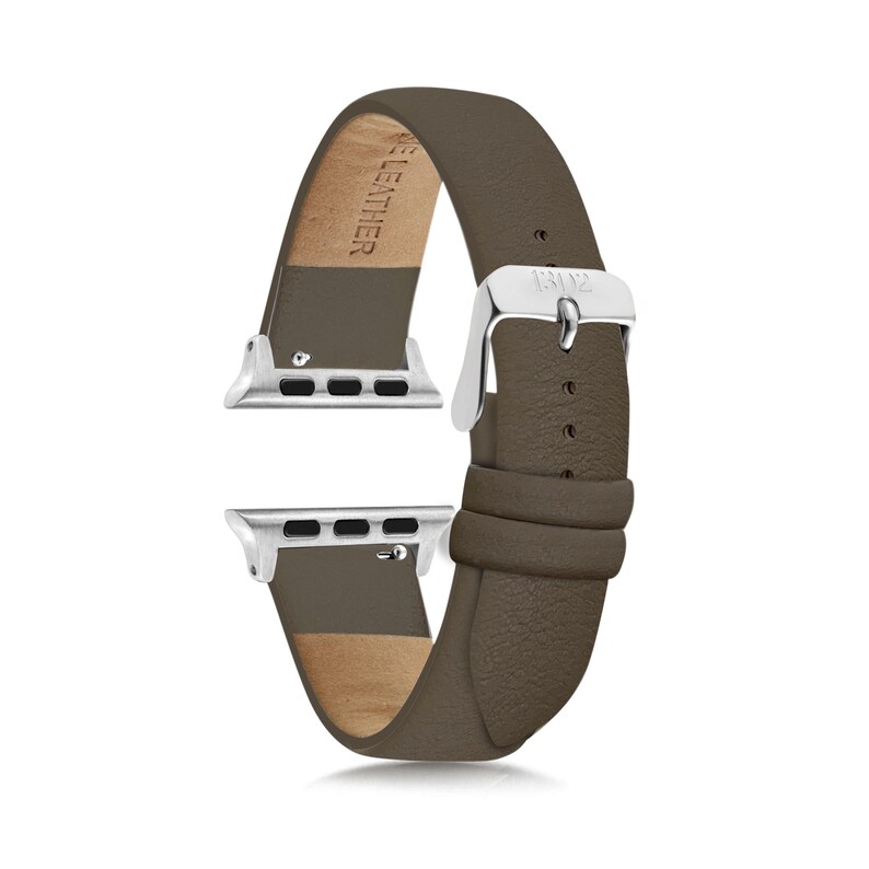May include: A taupe leather watch band featuring a silver-toned metal buckle and silver-toned attachment hardware. The interior of the band is embossed with the text GENUINE LEATHER, and the buckle is engraved with the letters BZ.