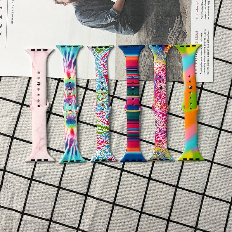 Puede incluir: Cinco correas de reloj de silicona de colores para Apple Watch. Las correas presentan diferentes patrones, incluyendo tie-dye, m&aacute;rmol y rayas.