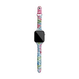 Puede incluir: Un Apple Watch blanco con una banda estampada floral azul, verde, rosa y roja.