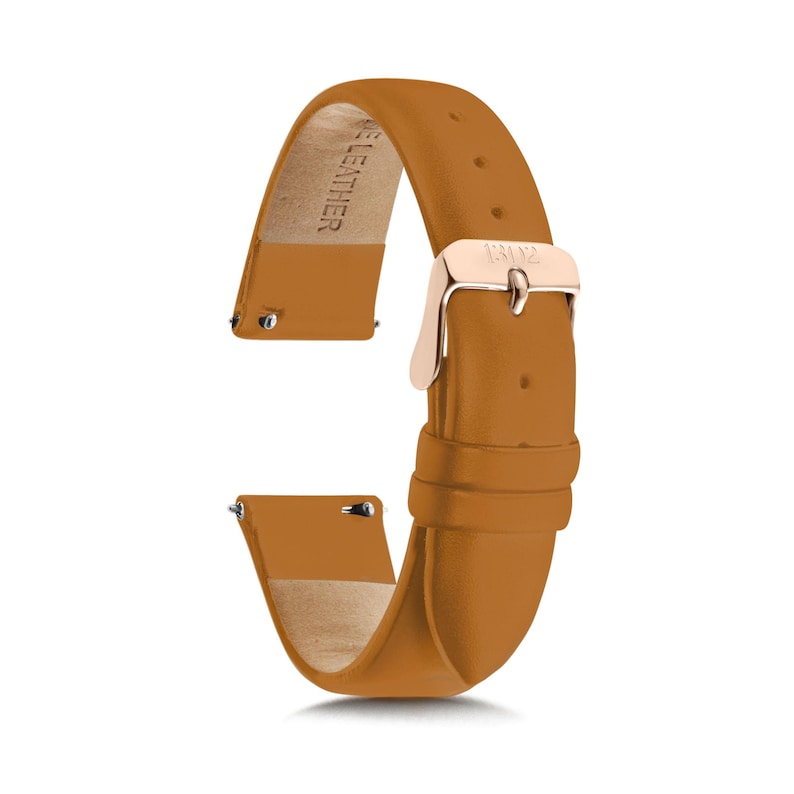 May include: A tan leather watch strap featuring a rose gold-toned metal buckle and a quick-release spring bar mechanism. The underside of the strap is lined with a light beige material and is embossed with the text GENUINE LEATHER.