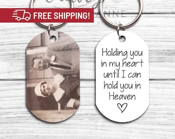 May include: A silver keychain with two oval-shaped tags. One tag features a black and white photograph of a couple. The other tag displays the text "Holding you in my heart until I can hold you in Heaven" with a small heart symbol.