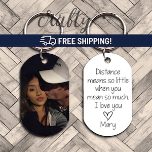 May include: A set of two keychains. One keychain features a black and white photo of a couple. The other keychain is white with the text "Distance means so little when you mean so much. I love you ♡ Mary".