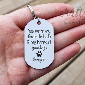 May include: White metal keychain with a paw print and the text "You were my favourite hello & my hardest goodbye Ginger".